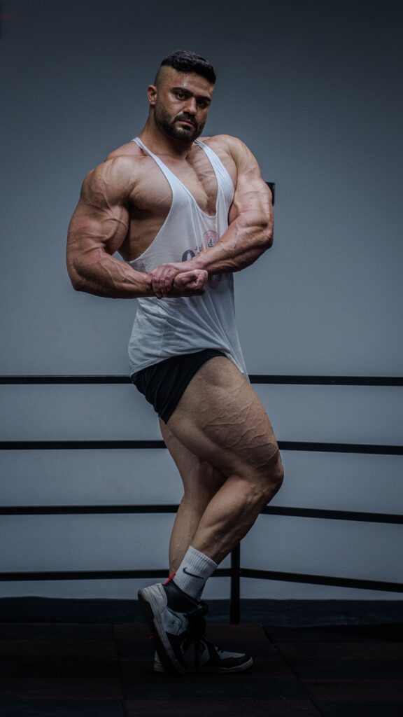 Strong bodybuilder showcasing muscles and fitness in a gym setting.