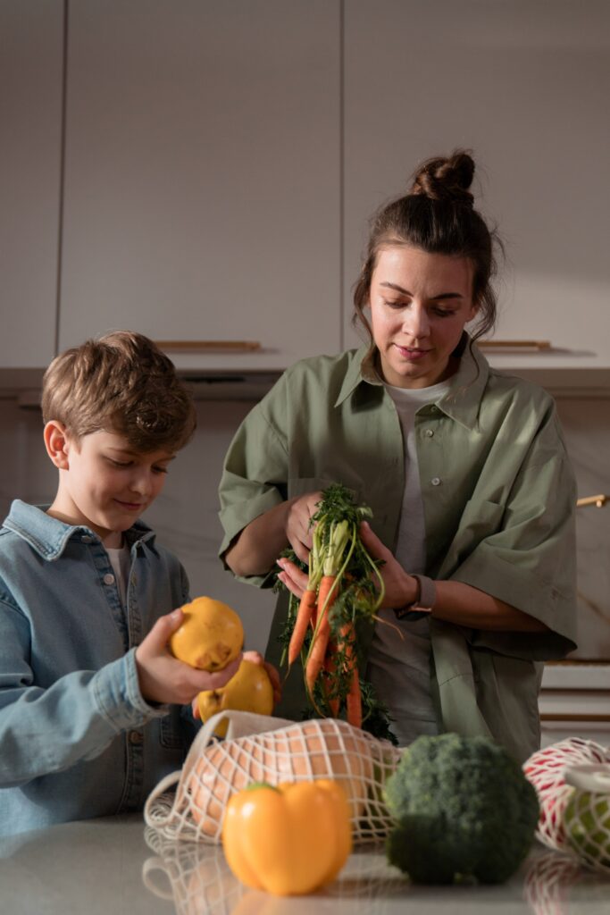 Mother and son preparing vegetables in the kitchen, promoting a healthy lifestyle.